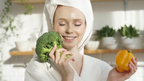 Portrait of a Woman in a Towel on Her Head She Holds Fresh Vegetables Pepper and Broccoli