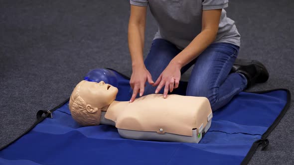 Giving first aid CPR on a dummy. 