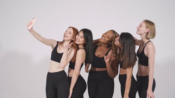 Portrait of Cheerful Diverse Women Taking Selfie Looking at Camera