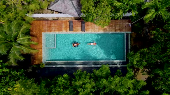 Couple Men and Woman in Swimming Pool in the Jungle of Krabi Thailand Aerial View with Drone Above