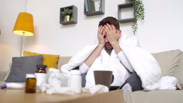 Sick Man with Headache Sitting on Couch