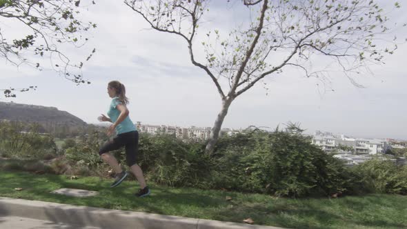 A young woman runner going for a run in a residential neighborhood.