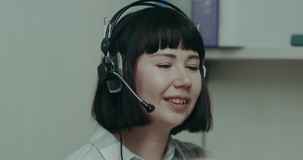 Pretty Young Female Operator Speaking with Client