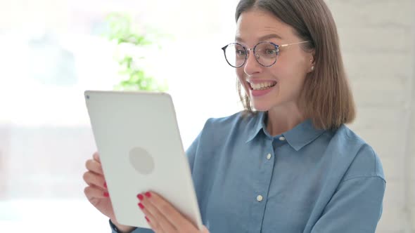 Young Woman Celebrating Success on Tablet