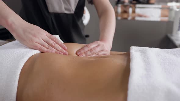 Masseur Hands which Making Stomach Massage by Circular Actions for Woman Client