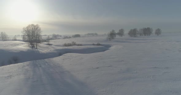 Aerial View of Cold Winter Landscape Arctic Field Trees Covered with Frost Snow Ice River and Sun