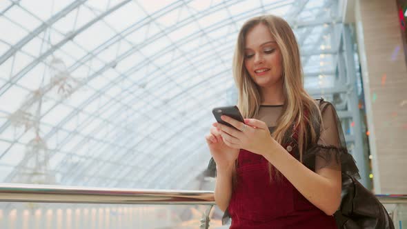 Girl Use Mobile Phone, Blur Image of Inside the Mall As Background