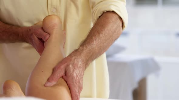 Female patient receiving leg massage from male physiotherapist