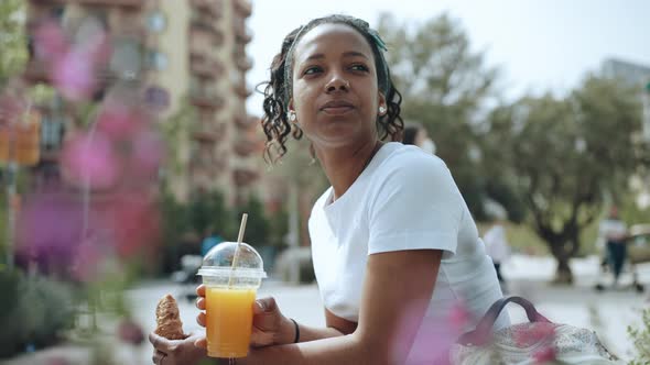 Handsome brunette African woman drinking juice