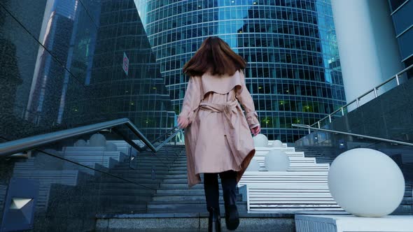 Woman Moves Up High Staircase Goes to Skyscraper