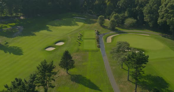 Tilt Up Aerial of a Golf Course Near a Forest