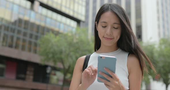 Woman typing on cellphone in city 