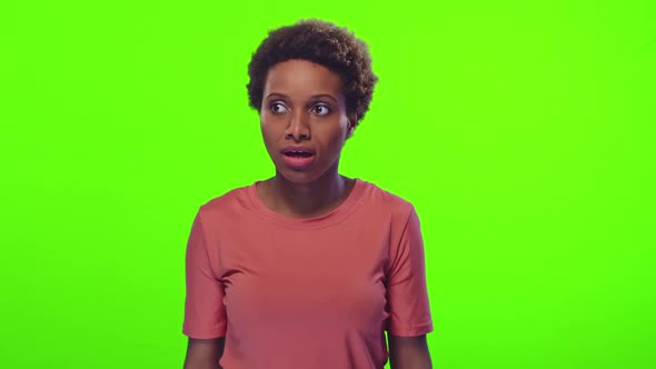 Young African American Woman Sneezes Covering Mouth with Hands and Smiling