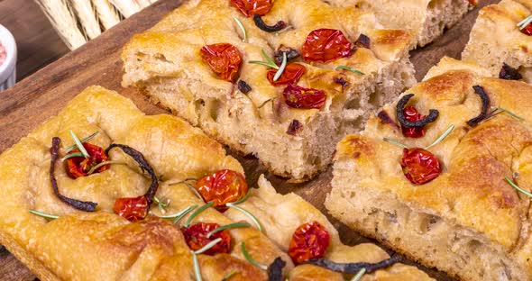 Homemade italian flat bread - Focaccia contorta. With olives, olive oil, rosemary, tomatoes. Traditi