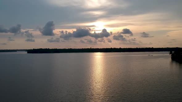 Beautiful aerial shot of a backwater canal, sunset,coconut trees ,water transportation,clouds,Blue s