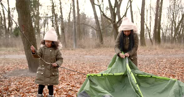 Black Race Sisters Putting a Tent in a Forest