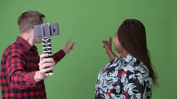 Overweight African Woman and Young Scandinavian Man Together Against Green Background