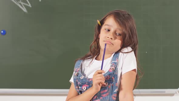 Portrait of Thoughtful Little Smiling Girl Holding Pencil. Genius Child with the Idea