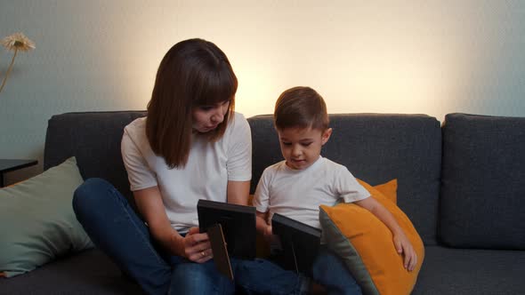 Smiling Young Woman Her Son Sitting Couch Looking Photographs