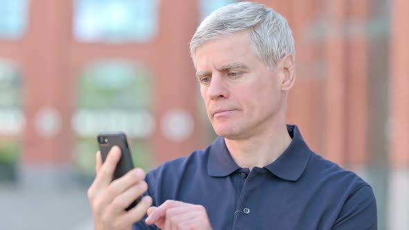 Outdoor Portrait of Middle Aged Man Get Shocked on Smartphone