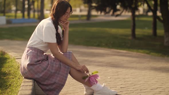 Woman with Flower Outdoors in the City Park