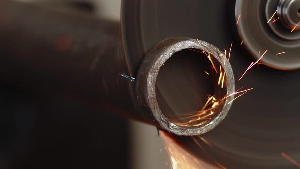 Closeup of How Round Piece is Cut Off From Metal Hollow Pipe Using Cutting Disc and an Angle Grinder