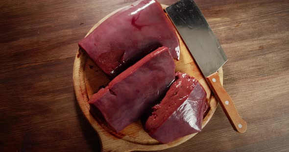On the Cutting Board Raw Liver with a Knife. 