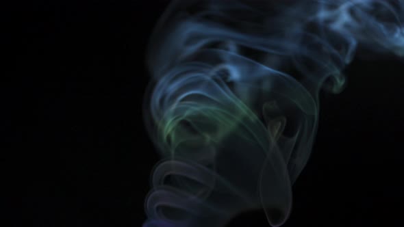 Abstract Colored Smoke Rises Up in Beautiful Swirls on a Black Background