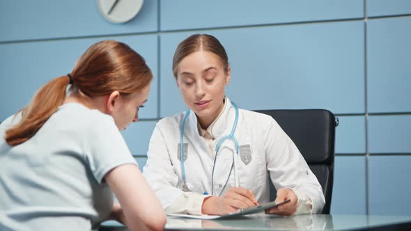 Young woman general practitioner explains patient results of examination