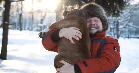 Close Up of Smiling Bearded Man Hugging and Gently Kissing His Cute Friend English Bulldog