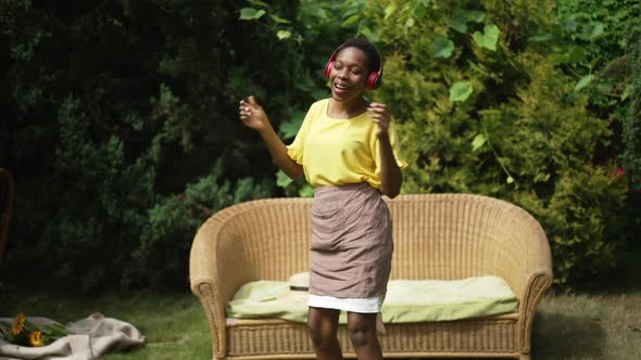 Happy Excited African American Woman Dancing in Slow Motion Listening to Music in Headphones Smiling