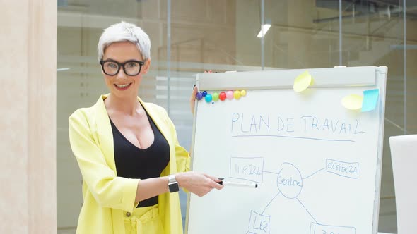 Confident Businesswoman Giving Presentation Using Flipchart