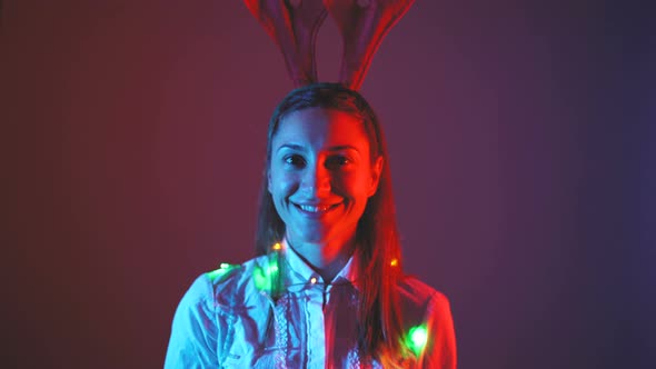 Portrait of Beautiful Smiling Woman with Christmas Lights Around Her Neck