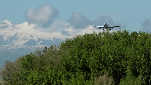 Jet airplane approaching with beautiful mountains at the background