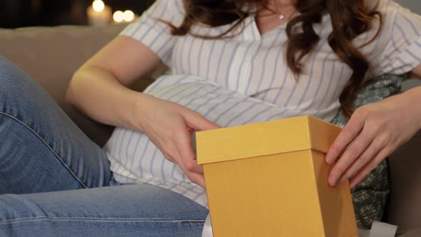 Happy Smiling Pregnant Woman with Gift Box at Home