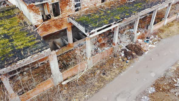 Ruined brick buildings with collapsed roofs. Aerial view.