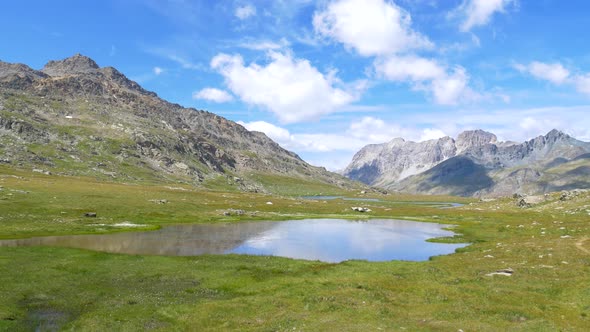 PAN: Idyllic blue alpine lake high up on the mountains, scenic landscape rocky terrain at high altit