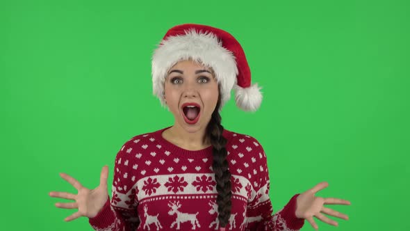 Portrait of Sweety Girl in Santa Claus Hat with Shocked Surprised Wow Face Expression. Green Screen