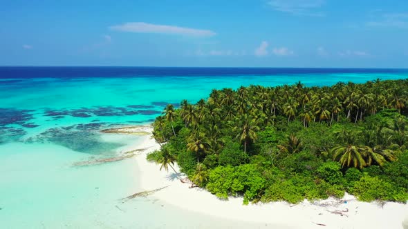 Aerial flying over scenery of paradise seashore beach break by clear lagoon and white sandy backgrou