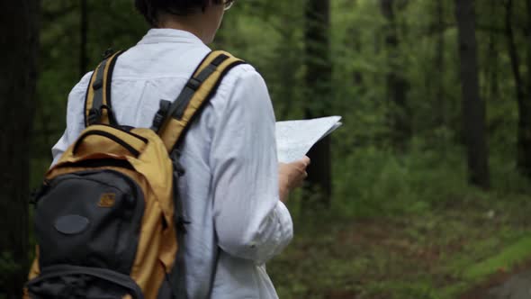 Young  Woman  Traveler  With  Backpack  Walks,  Looks  At  Map,  European  Tourist  On  Hike