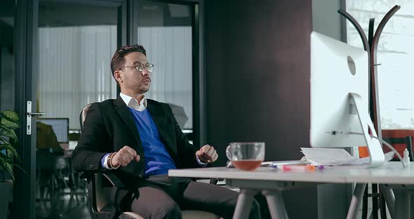 Businessman in the Office in Front of the Computer Showing Anger