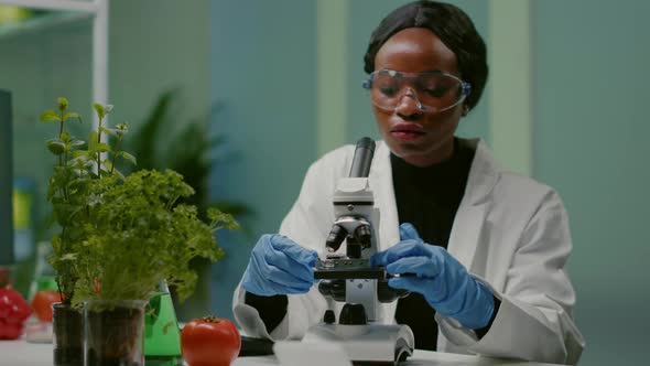 Portrait of Pharmaceutical Woman Putting Slide Under Microscope