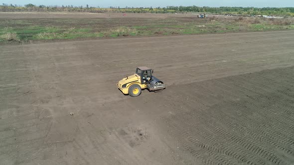 Aerial View of a Compactor Leveling the Soil in the Field Heavy Machinery