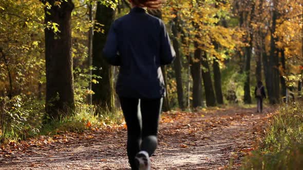 Young woman jogging through forest