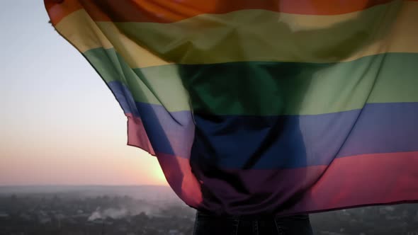 Woman Waving Rainbow LGBT Flag on Sunset