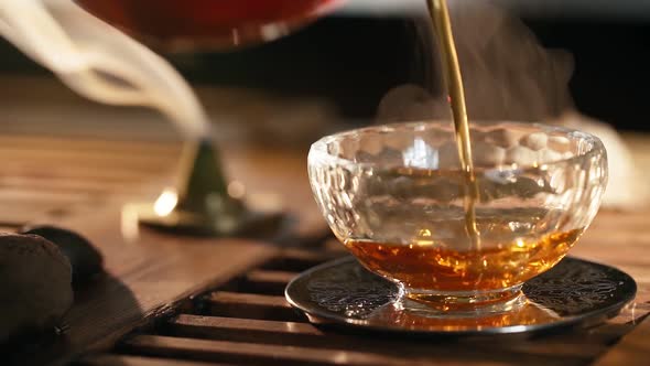 Tea Poured Into Glass Background Smoke Scented Sticks Backlit By Warm Light