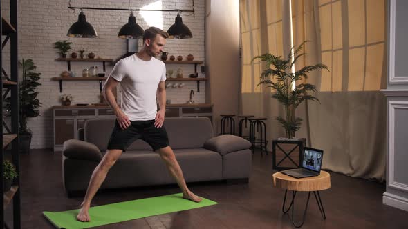 Fit Man Practicing Yoga with Online Trainer Indoor