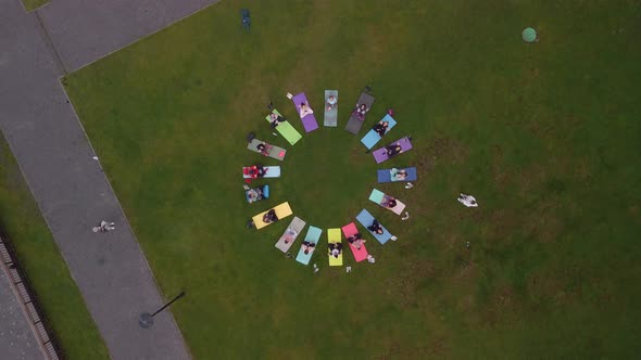 Aerial View of a Large Group of Women Doing Gymnastics Sitting on Mats