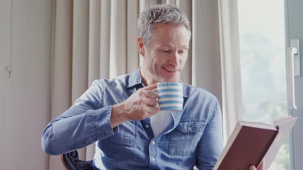 Man reading a book while having coffee 4k