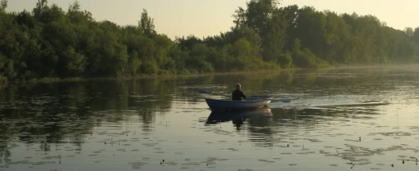 A Man Is Floating on a River on a Boat